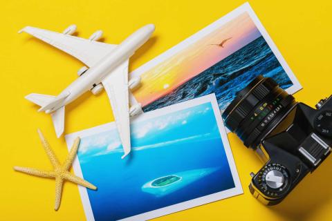 Yellow background featuring two beachy postcards, camera, airplane, and starfish