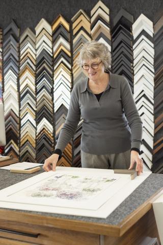 Woman posing with painting and frame