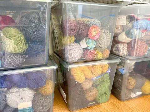 Clear storage bins filled with yarn