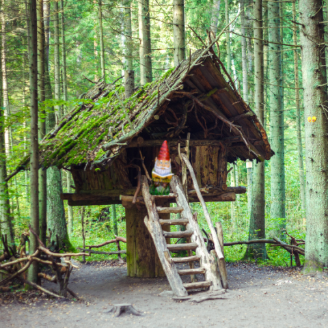 A small house in the woods with a gnome.