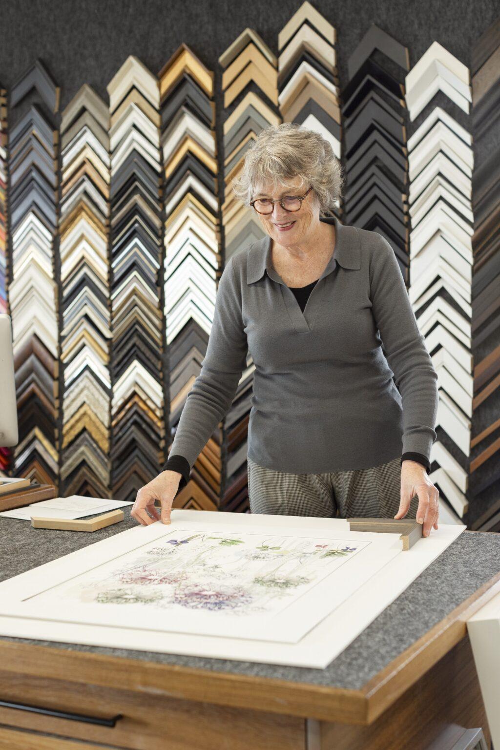 Woman posing with painting and frame